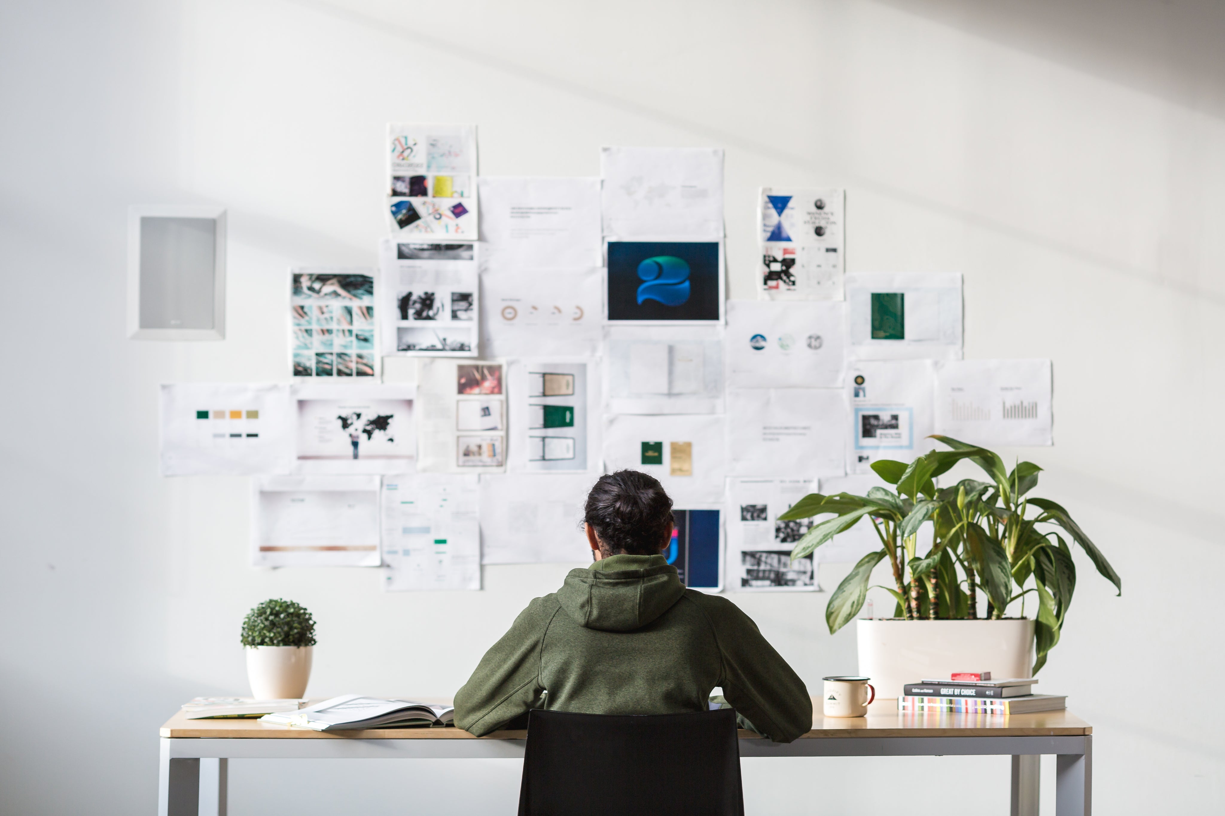 Designer at desk with wall of notes